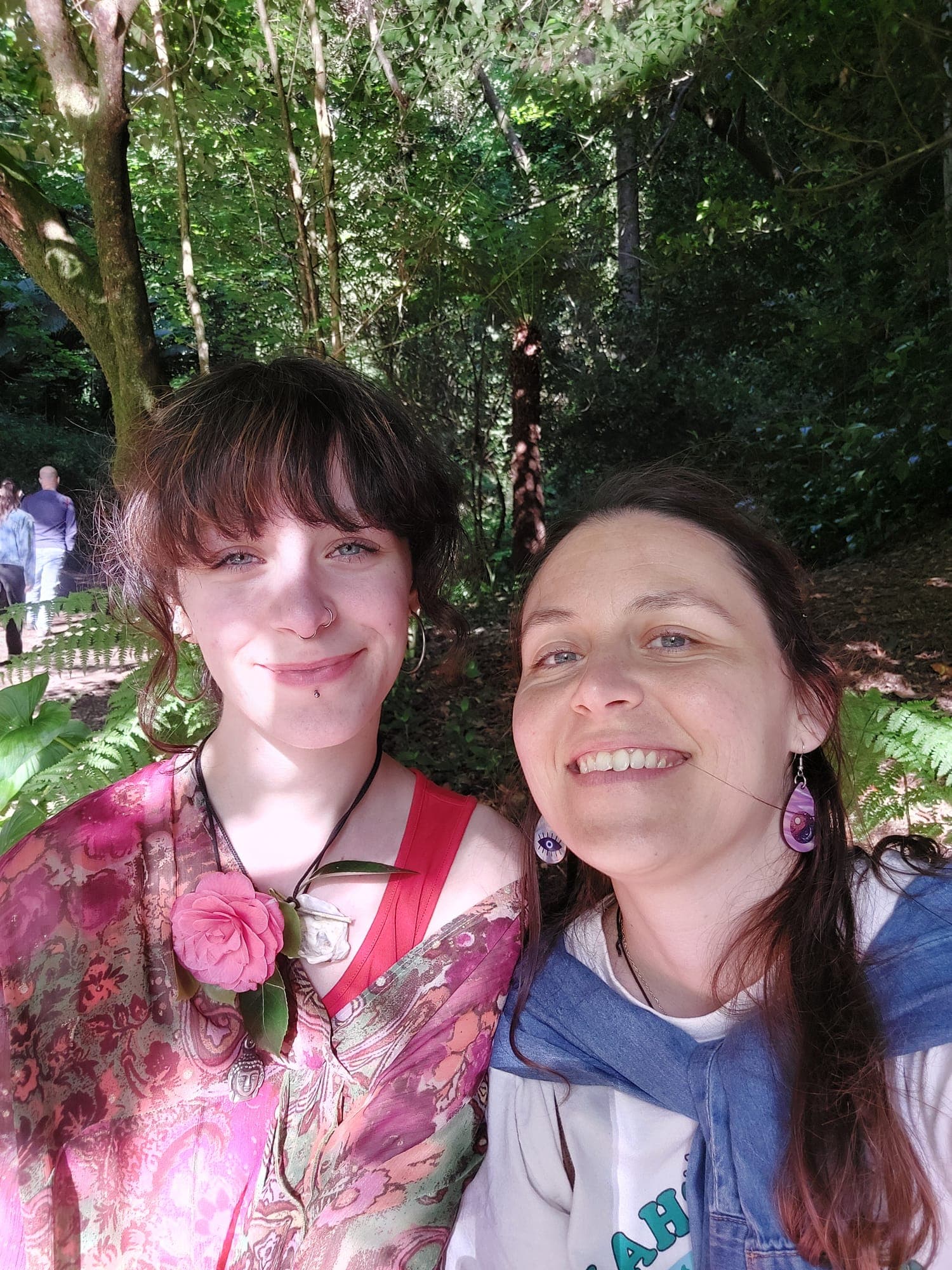 duas mulheres a sorrir numa selfie, numa floresta